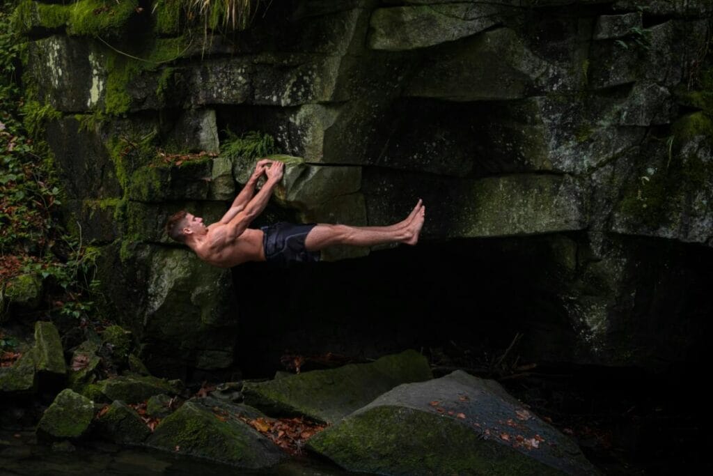 Strong man rock climbing in nature, representing how to naturally boost testosterone.