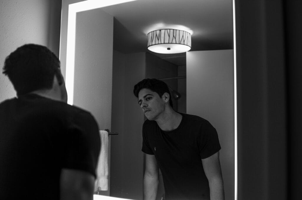 Minimalist portrait of man looking in the mirror – men’s skincare without gimmicks