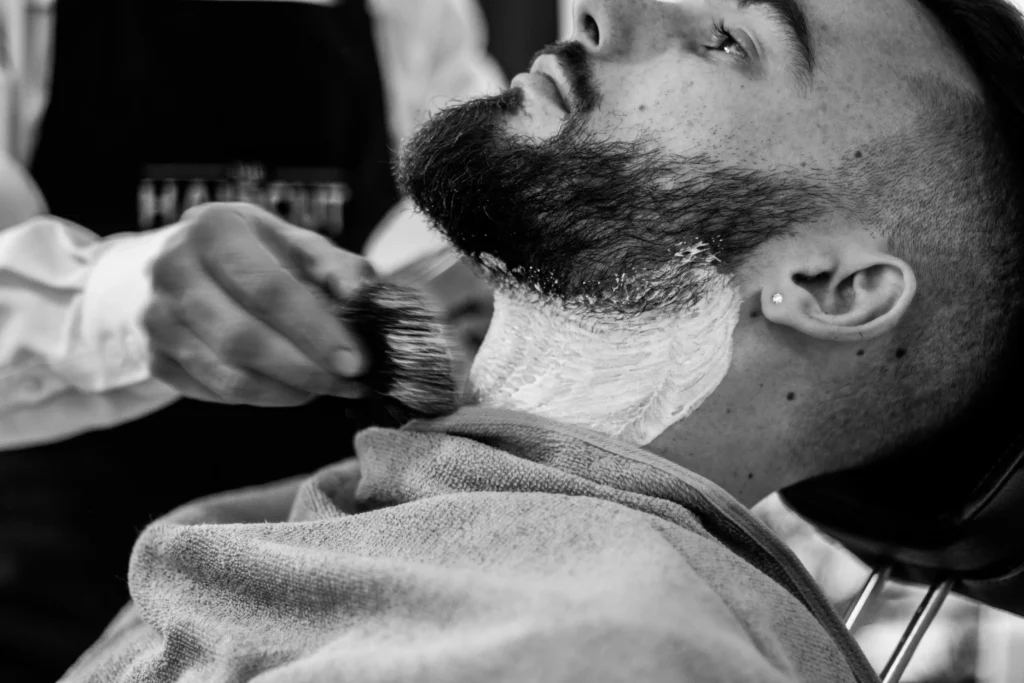 Barber shaping a man's beard neckline for a clean, well-groomed look