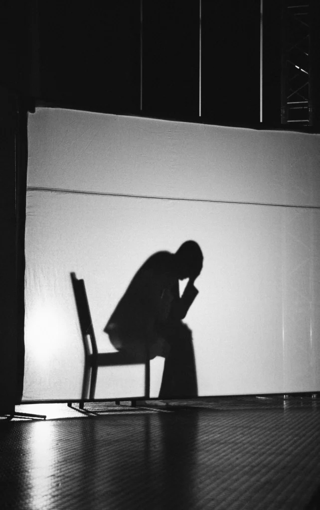 hadow of a man sitting exhausted on a chair — Overtraining and Testosterone effects on body and mind