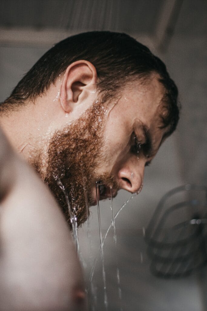 Man washing face with water – cleansing step of a men’s skincare routine